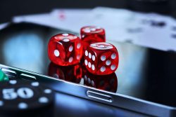 Tre speltärningar ligger på en smartphone.